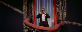 Movie still from “Daddy Long Legs” (1955), directed by Jean Negulesco – A man in a tuxedo is taking a picture of himself in a mirror; Medium shot, High angle