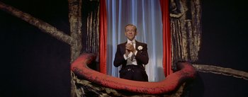 Movie still from “Daddy Long Legs” (1955), directed by Jean Negulesco – A man in a tuxedo clapping his hands in front of a mirror; Medium shot, Low angle