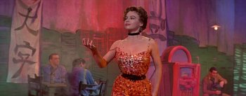 Movie still from “Daddy Long Legs” (1955), directed by Jean Negulesco – A wax statue of a woman in a red dress; Medium shot, Low angle
