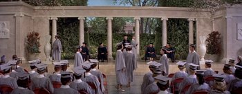 Movie still from “Daddy Long Legs” (1955), directed by Jean Negulesco – A group of people wearing graduation caps and gowns in front of an audience; Wide shot, High angle