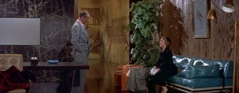 Movie still from “Daddy Long Legs” (1955), directed by Jean Negulesco – A man and a woman are talking in a lobby; Wide shot, Over the shoulder angle