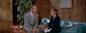 Movie still from “Daddy Long Legs” (1955), directed by Jean Negulesco – A man and a woman sitting next to each other on a couch; Medium shot, Over the shoulder angle