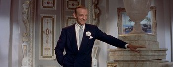 Movie still from “Daddy Long Legs” (1955), directed by Jean Negulesco – A man in a suit and tie smiling; Medium shot, Low angle