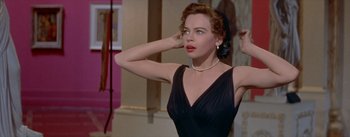 Movie still from “Daddy Long Legs” (1955), directed by Jean Negulesco – A woman in a black dress and a pearl necklace; Close Up shot, Low angle