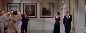 Movie still from “Daddy Long Legs” (1955), directed by Jean Negulesco – A man and a woman standing in front of two paintings; Wide shot, Low angle