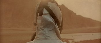 Movie still from “The Hills Have Eyes” (2006), directed by Alexandre Aja – A person wearing a space suit on the side of a mountain; Close Up shot, Low angle