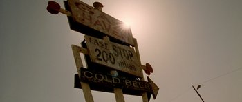 Movie still from “The Hills Have Eyes” (2006), directed by Alexandre Aja – The sun is shining on a street sign; Extreme Close Up shot, Low angle