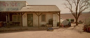 Movie still from “The Hills Have Eyes” (2006), directed by Alexandre Aja – A toy car sitting in front of an old building; Extreme Wide shot, High angle
