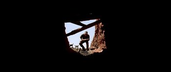 Movie still from “The Hills Have Eyes” (2006), directed by Alexandre Aja – A man standing on top of a train tracks; Wide shot, Low angle