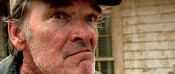Movie still from “The Hills Have Eyes” (2006), directed by Alexandre Aja – A person wearing a hat and looking at the camera; Extreme Close Up shot, Low angle