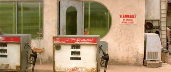 Movie still from “The Hills Have Eyes” (2006), directed by Alexandre Aja – An old gas pump sitting next to a building; Wide shot, High angle