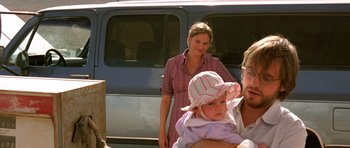 Movie still from “The Hills Have Eyes” (2006), directed by Alexandre Aja – A woman holding a baby in front of a van; Medium shot, Low angle