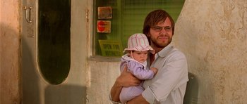 Movie still from “The Hills Have Eyes” (2006), directed by Alexandre Aja – A man holding a baby in his arms outside; Close Up shot, Over the shoulder angle