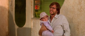 Movie still from “The Hills Have Eyes” (2006), directed by Alexandre Aja – A man holding a baby in his arms outside; Close Up shot, Over the shoulder angle