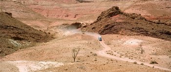 Movie still from “The Hills Have Eyes” (2006), directed by Alexandre Aja – A truck driving down a dirt road in the middle of the desert; Extreme Wide shot, High angle
