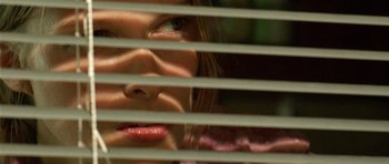 Movie still from “The Hills Have Eyes” (2006), directed by Alexandre Aja – A person looking through blinds; Extreme Close Up shot, High angle
