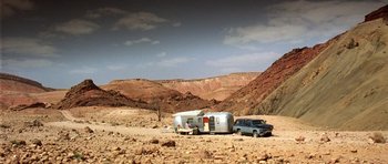 Movie still from “The Hills Have Eyes” (2006), directed by Alexandre Aja – An airstream trailer parked in the middle of the desert; Extreme Wide shot, Low angle