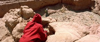 Movie still from “The Hills Have Eyes” (2006), directed by Alexandre Aja – A person in a red jacket is standing on rocks; Extreme Wide shot, High angle