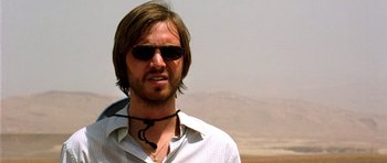Movie still from “The Hills Have Eyes” (2006), directed by Alexandre Aja – A person wearing sunglasses and a white shirt; Close Up shot, Low angle