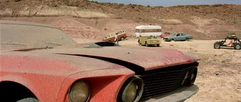 Movie still from “The Hills Have Eyes” (2006), directed by Alexandre Aja – An old car is parked in the middle of the desert; Wide shot, Low angle