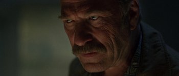 Movie still from “The Hills Have Eyes” (2006), directed by Alexandre Aja – An old man with a mustache and a mustache on his head; Extreme Close Up shot, Low angle
