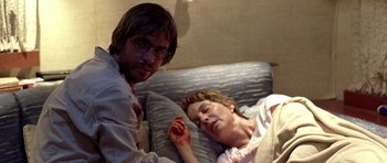 Movie still from “The Hills Have Eyes” (2006), directed by Alexandre Aja – A man and a woman laying in a bed; Medium shot, Over the shoulder angle