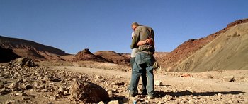 Movie still from “The Hills Have Eyes” (2006), directed by Alexandre Aja – A man and a woman hugging in the desert; Wide shot, Low angle