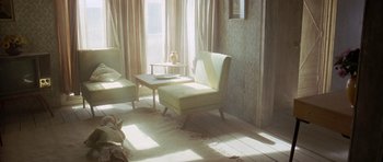 Movie still from “The Hills Have Eyes” (2006), directed by Alexandre Aja – A living room filled with furniture next to a large window; Wide shot, High angle