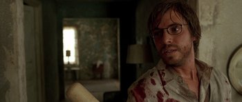 Movie still from “The Hills Have Eyes” (2006), directed by Alexandre Aja – A man with a bloody shirt holding a baseball bat in a room; Close Up shot, Over the shoulder angle