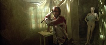 Movie still from “The Hills Have Eyes” (2006), directed by Alexandre Aja – A man holding a baseball bat with blood on it; Medium shot, Over the shoulder angle