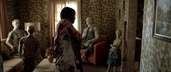 Movie still from “The Hills Have Eyes” (2006), directed by Alexandre Aja – A man in a living room holding a cane; Wide shot, Over the shoulder angle