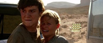 Movie still from “The Hills Have Eyes” (2006), directed by Alexandre Aja – A young man and a young woman standing next to each other in the desert; Close Up shot, Low angle