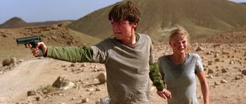 Movie still from “The Hills Have Eyes” (2006), directed by Alexandre Aja – A young man and a young woman walking through the desert; Medium shot, Low angle