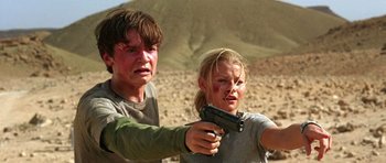 Movie still from “The Hills Have Eyes” (2006), directed by Alexandre Aja – A man and a woman holding a gun in the desert; Medium shot, Low angle