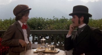 Movie still from “Daisy Miller” (1974), directed by Peter Bogdanovich – A man and a woman sitting at a table talking to each other; Medium shot, Over the shoulder angle