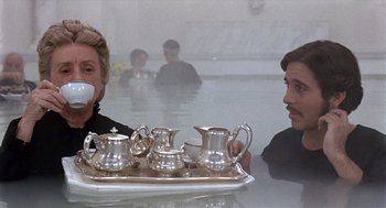 Movie still from “Daisy Miller” (1974), directed by Peter Bogdanovich – A man and a woman sitting in front of a silver tray; Medium shot, Over the shoulder angle