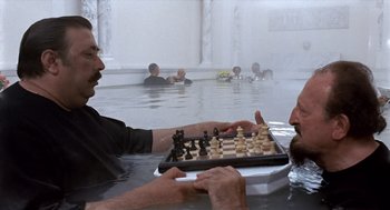 Movie still from “Daisy Miller” (1974), directed by Peter Bogdanovich – Two men are playing chess in the water; Medium shot, High angle