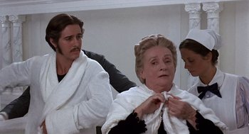 Movie still from “Daisy Miller” (1974), directed by Peter Bogdanovich – A man and a woman in white robes and a woman in a white robe; Medium shot, Over the shoulder angle