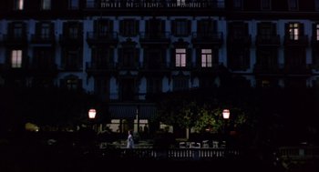 Movie still from “Daisy Miller” (1974), directed by Peter Bogdanovich – A person standing in front of a building at night; Extreme Wide shot, Low angle