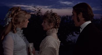 Movie still from “Daisy Miller” (1974), directed by Peter Bogdanovich – A group of people standing next to each other at night; Medium shot, Over the shoulder angle
