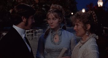Movie still from “Daisy Miller” (1974), directed by Peter Bogdanovich – Two women and a man standing next to each other; Medium shot, Over the shoulder angle