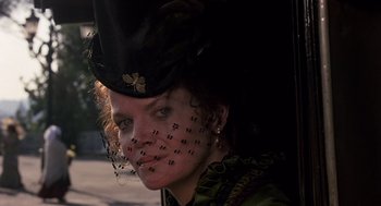 Movie still from “Daisy Miller” (1974), directed by Peter Bogdanovich – A woman wearing a black hat and a green dress; Close Up shot, Low angle