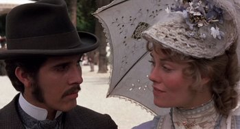 Movie still from “Daisy Miller” (1974), directed by Peter Bogdanovich – A man and a woman wearing hats and holding an umbrella; Close Up shot, Low angle