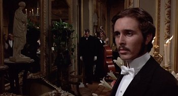 Movie still from “Daisy Miller” (1974), directed by Peter Bogdanovich – A man in a tuxedo standing next to a violin; Close Up shot, Low angle