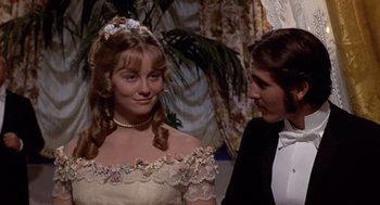 Movie still from “Daisy Miller” (1974), directed by Peter Bogdanovich – A woman in a white dress and a man in a tuxedo; Close Up shot, Over the shoulder angle