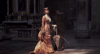 Movie still from “Daisy Miller” (1974), directed by Peter Bogdanovich – A man and a woman dressed in period clothing; Wide shot, Low angle