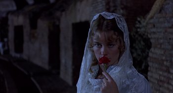 Movie still from “Daisy Miller” (1974), directed by Peter Bogdanovich – A woman in a white veil holding a red rose; Close Up shot, Over the shoulder angle