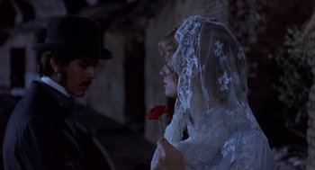 Movie still from “Daisy Miller” (1974), directed by Peter Bogdanovich – A man and a woman holding a red rose in front of each other; Close Up shot, High angle