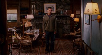 Movie still from “Dan in Real Life” (2007), directed by Peter Hedges – A man standing in front of a stone fireplace; Wide shot, High angle