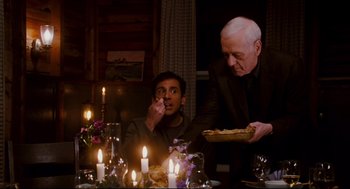 Movie still from “Dan in Real Life” (2007), directed by Peter Hedges – A man sitting at a dinner table with a tray of food in front of him; Medium shot, High angle